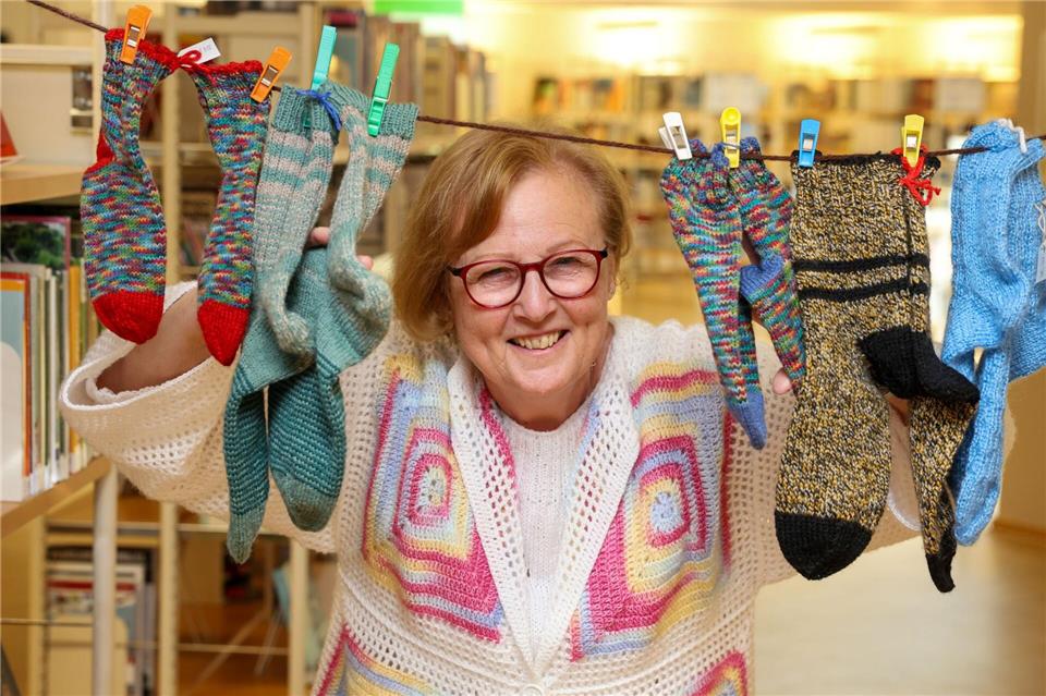 Karin Stern, Leiterin vom Strickkurs, zeigt die ersten Socken beim Weltrekordversuch in der Magdeburger Stadtbibliothek.Peter Gercke/dpa