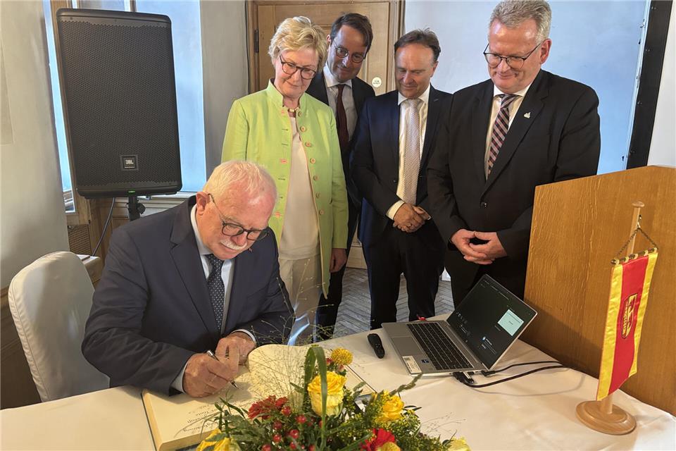 Karl-Heinz Tünte trägt sich ins goldene Buch ein.
