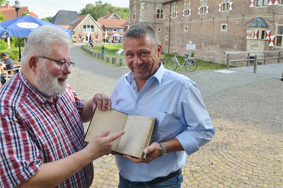 Karl-Heinz Zeh (links) überreicht das Bürgermeister-Buch an seinen Nachfolger Gerd Bannefeld. 