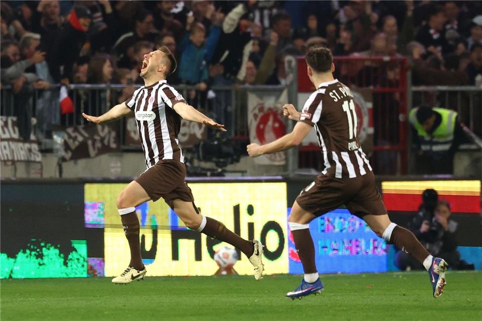 Karol Mets (l) feiert seinen Treffer zum 1:0 für den FC St. Pauli.Christian Charisius/dpa
