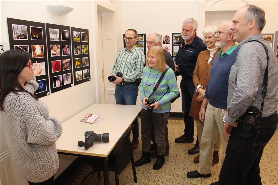 Kathleen Mielke (links) zeigt der Foto-AG und ihrem Leiter Frank Bena (rechts) ihre Aufnahmen in der Ausstellung.