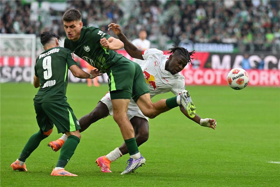 1:0 in Wolfsburg: Leipziger Siegesserie hält an Kaum zu stoppen: Leipzigs Torschütze Johan Bakayoko (r) wird von den Wolfsburgern Joakim Maehle und Mohammed Amoura bedrängt.Swen Pförtner/dpa