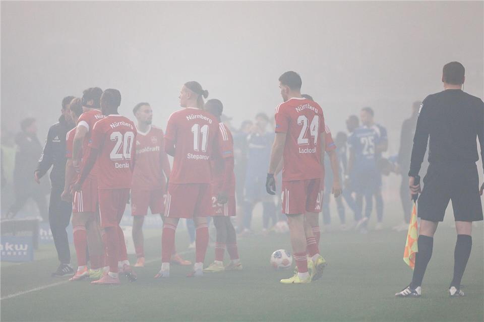 Kein Durchblick mehr: Das Abbrennen von Pyro-Technik sorgt für eine längere Spielunterbrechung. Andreas Gora/dpa