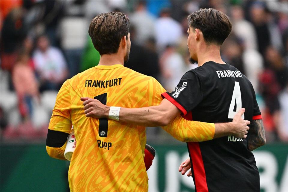 Kevin Trapp (l) fehlt im Pokal-Kader von Eintracht Frankfurt und hat die Kapitänsbinde an Robin Koch abgegeben.Jan-Philipp Strobel/dpa