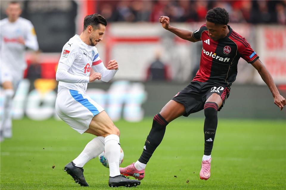 Kiel-Kapitän Steven Skrzybski (links) und Pape Demba Diop von Nürnberg kämpfen um den Ball.Daniel Karmann/dpa