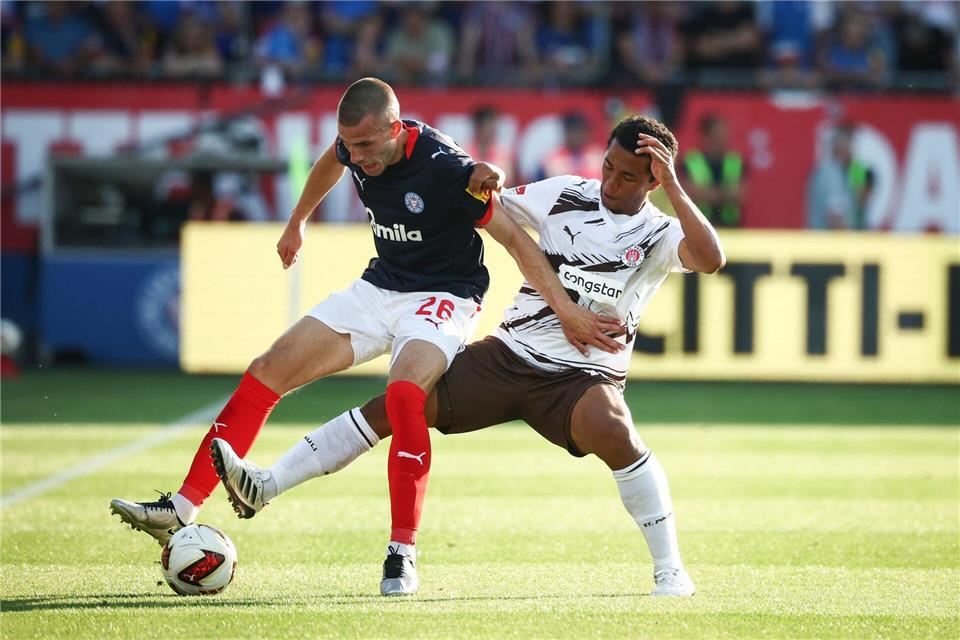 Kiels David Zec (l) wird von St. Paulis Joel Fujita attackiert.Christian Charisius/dpa
