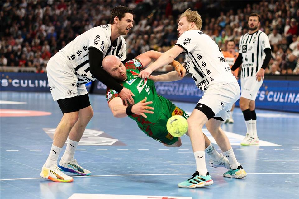 Kiels Hendrik Pekeler (l-r), Magdeburgs Oscar Bergendahl und Kiels Eric Johansson kämpfen um den Ball.Frank Molter/dpa