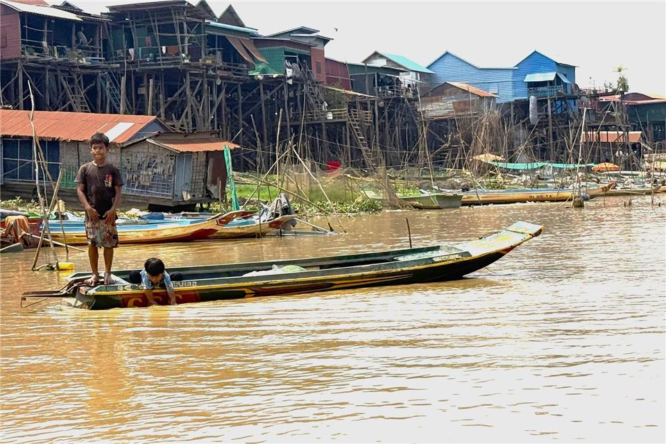 Kinder fahren am Tonle Sap mit Booten zur Schule.Carola Frentzen/dpa