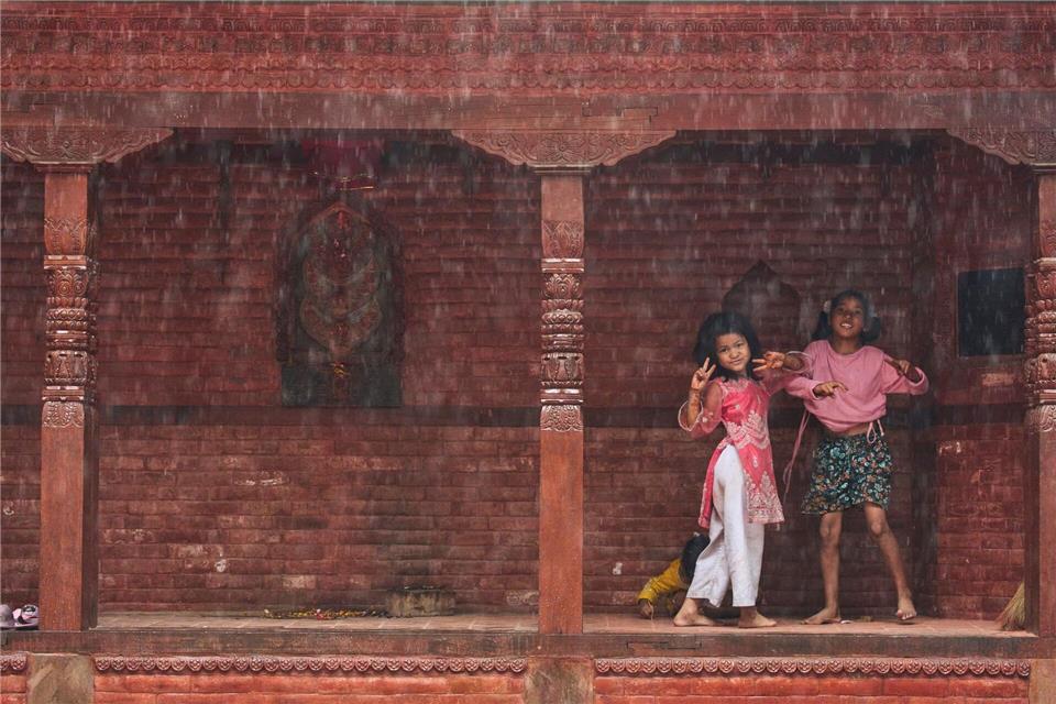 Kinder gestikulieren, während sie bemerken, dass sie während des Monsuns fotografiert werden.Niranjan Shrestha/AP/dpa