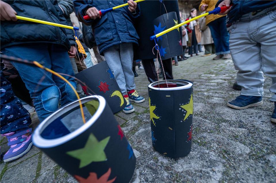 Kinder zeigen ihre gebastelten Laternen. Pia Bayer/dpa