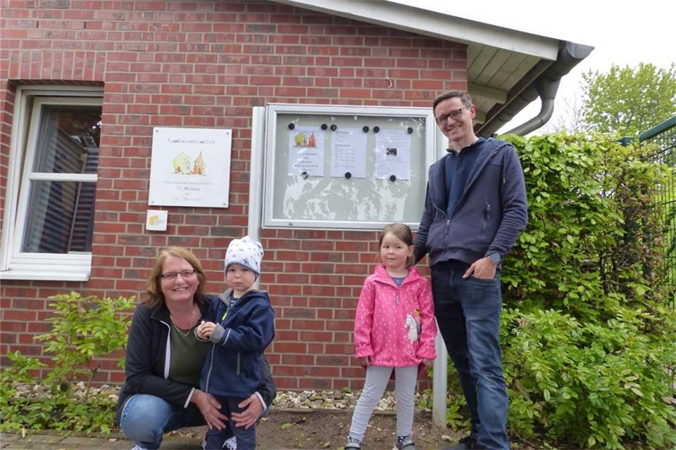 Kita-Leiterin Mechthild Westerkamp, Linus, Hanna und Vater Jonathan Schmidt freuen sich über den neuen Schaukasten.