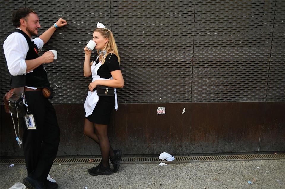 Kleine Pause für die Wiesn-Bewirtung: Bedienung Christina und Kellner Cedric  hinter dem Schottenhamel Festzelt auf dem Oktoberfest. Felix Hörhager/dpa