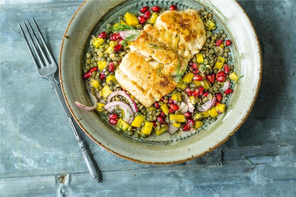 Kleine grüne Linsen, gelbe Mango-Stückchen und rote Granatapfelkerne sorgen bei diesem raffinierten Salat von Inga Pfannebecker für ein Farbenfeuerwerk. Wolfgang Schardt/Gräfe und Unzer/dpa-tmn