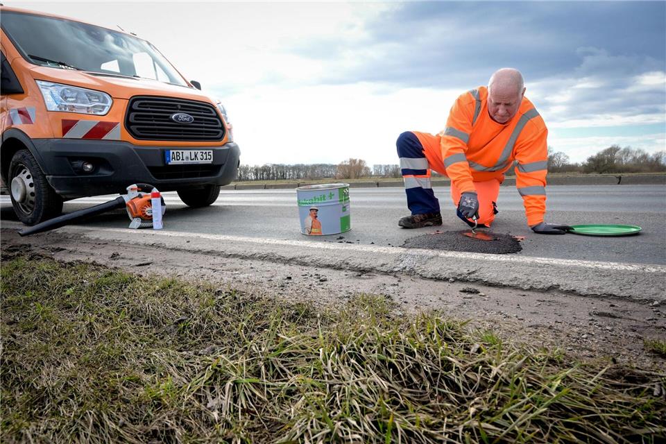 Kleinere Löcher werden vielerorts aktuell mit Kaltasphalt repariert. Heiko Rebsch/dpa