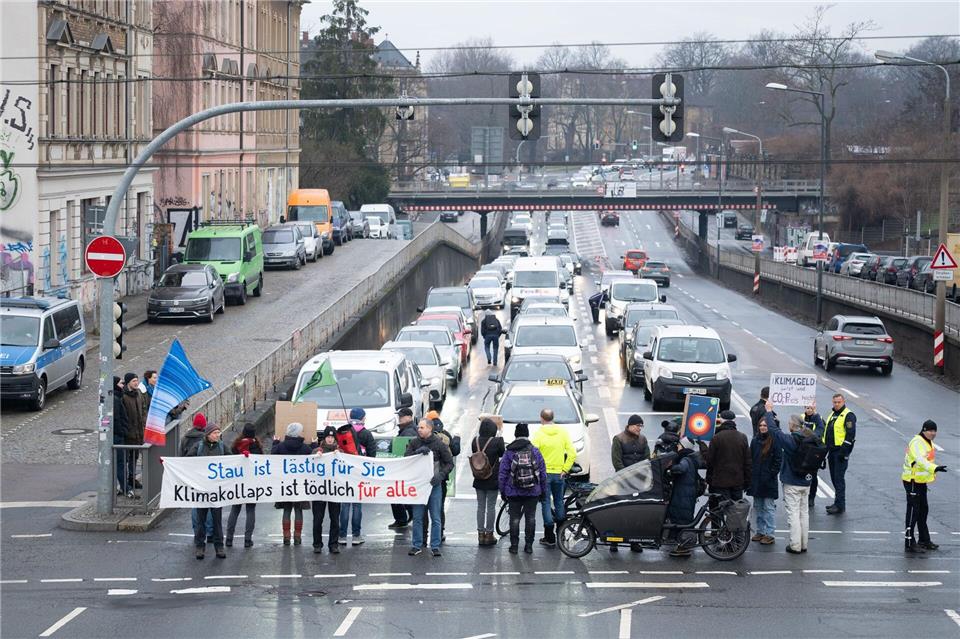 Klima-Aktivsten haben bei einer Straßenblockade eine „Wärmewende“ in Dresden hin zu erneuerbaren Wärmequellen verlangt. Sebastian Kahnert/dpa