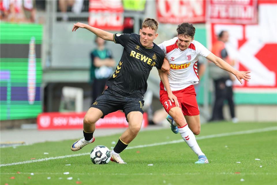 Köln-Neuzugang Isak Johannesson kämpft gegen Regensburg Leo Mätzler um den Ball.Daniel Löb/dpa
