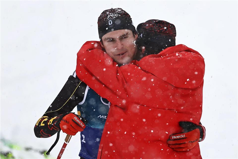 Kombinierer Vinzenz Geiger muss nach der vergebenen Olympia-Medaille von Johannes Rydzek getröstet werden.Daniel Karmann/dpa