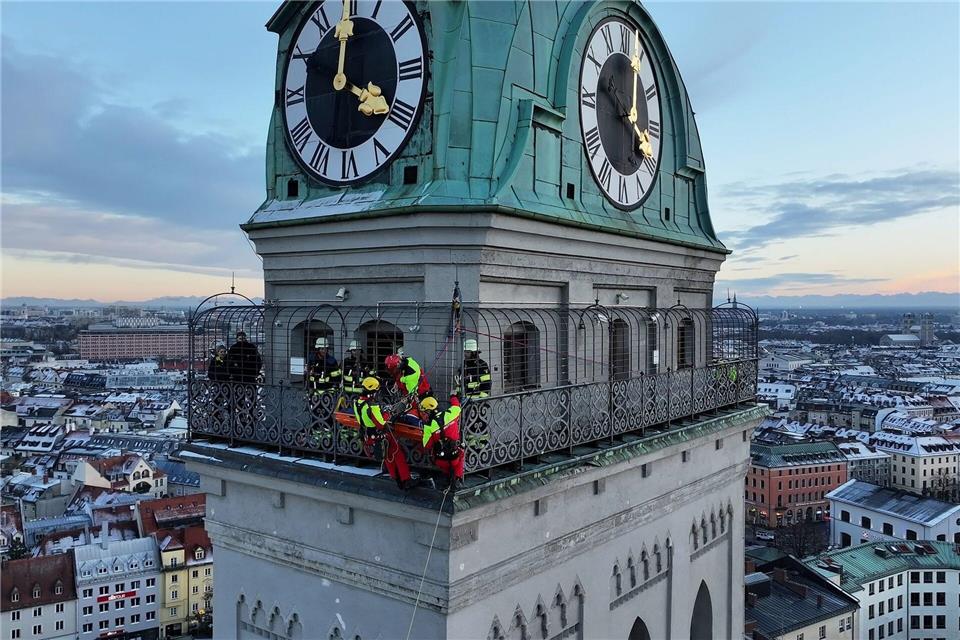 Kräfte der Berufsfeuerwehr München sind am Turm der Kirche St. Peter im Einsatz. -/Berufsfeuerwehr München/dpa