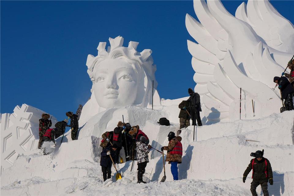 Künstler arbeiten an einer Schneeskulptur. Wang Song/XinHua/dpa