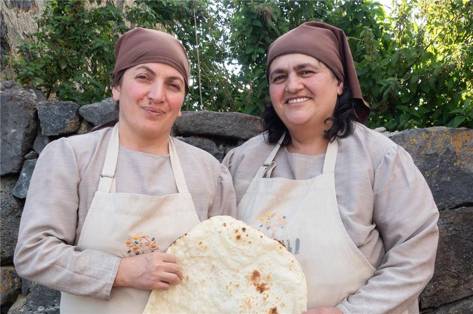 Kulturerbe aus dem Erdofen: Gohar Gareginyan (l) und Anna Yesayan mit einem frisch gebackenen Fladenbrot.Andreas Drouve/dpa-tmn
