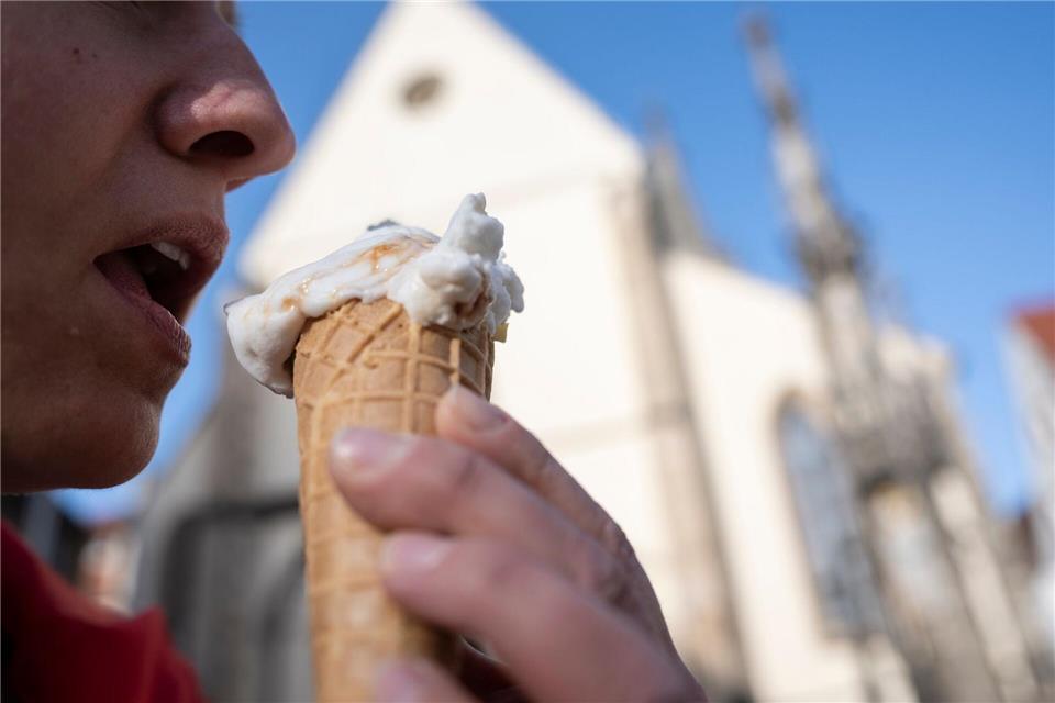 Kundin Simone Schmid isst auf dem Marktplatz ein Kamelmilch-Eis. Marijan Murat/dpa