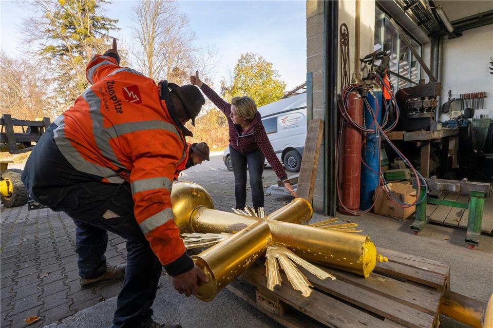 Kunstschmiedin Andrea Würzinger soll die dicke Schicht Aufkleber entfernen, den Untergrund schleifen sowie Lack und neues Blattgold aufbringen.Peter Kneffel/dpa
