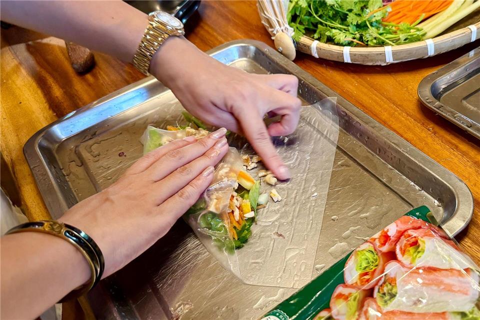 Kursleiterin Alice erklärt, wie frische Sommerrollen richtig zubereitet werden.Carola Frentzen/dpa-tmn