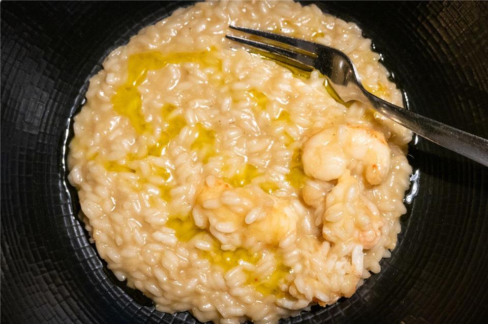 Kurz vorm Servieren gibt Küchenchef Kruno Kapetanović noch einen Schuss Olivenöl über das Scampi-Risotto.Andreas Drouve/dpa-tmn