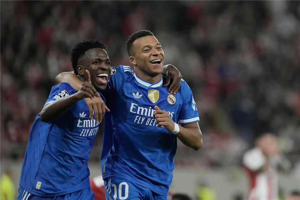 Kylian Mbappé (r) und Vinicius Junior von Real Madrid feiern den Champions-League-Sieg in Piräus.Petros Giannakouris/AP/dpa