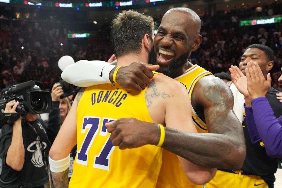 LeBron James (Mitte) feiert mit Luka Doncic den Sieg in Miami.Lynne Sladky/AP/dpa