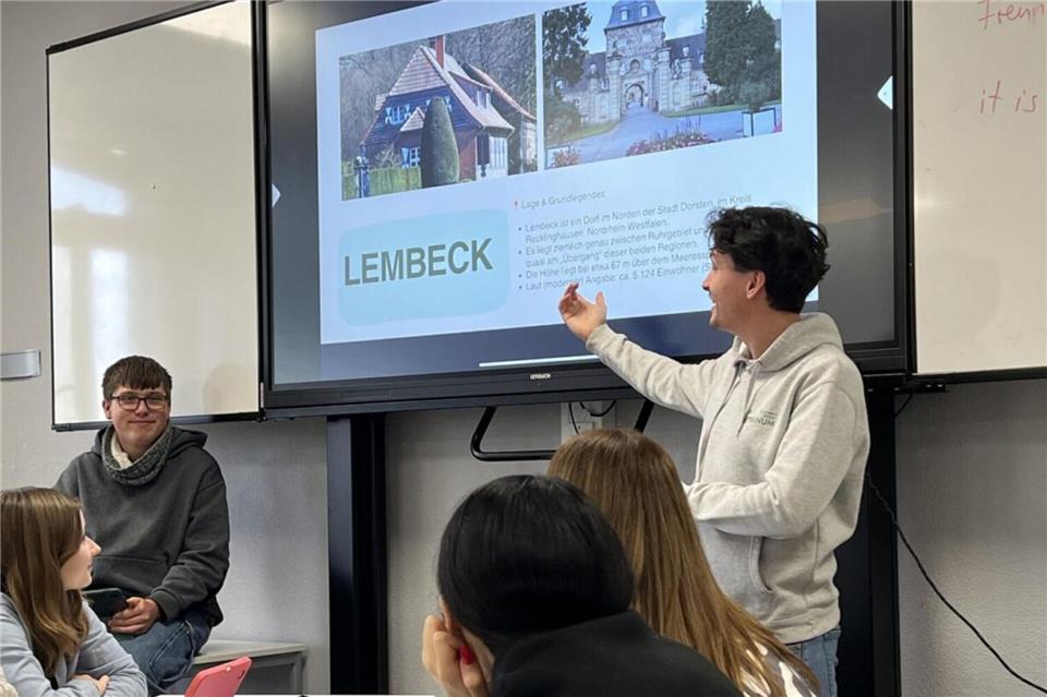 Lehrer Tristan Gayda steht an einer digitalen Tafel. Mit seinem Kurs bespricht er die verschiedenen Dorstener Stadtteile und ihre Besonderheiten.