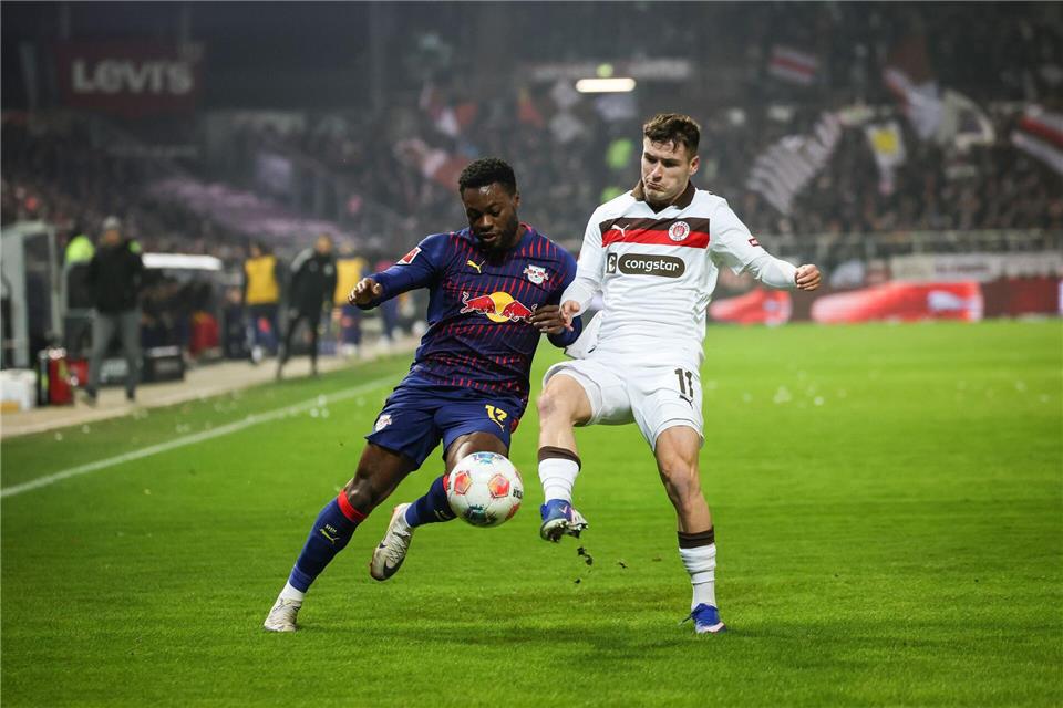 Leipzigs Ridle Baku (l) und St. Paulis Arkadiusz Pyrka kämpfen um den Ball.Christian Charisius/dpa