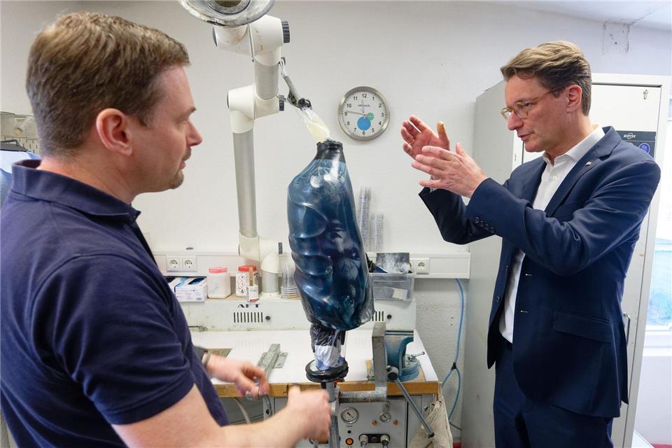 Leistungssport trotz Handicap - Nordrhein-Westfalens Ministerpräsident Hendrik Wüst (CDU) lässt sich erklären, worauf es etwa bei einer Prothese ankommt. Henning Kaiser/dpa