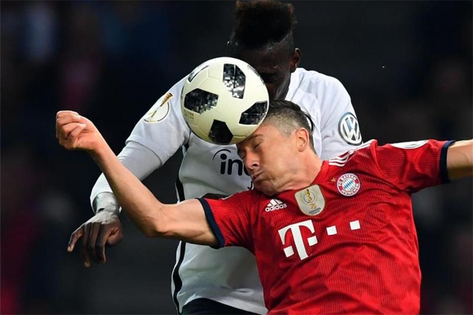 Lewandowski (unten) beim Kopfballduell mit Frankfurts Danny da Costa. Foto: Soeren Stache