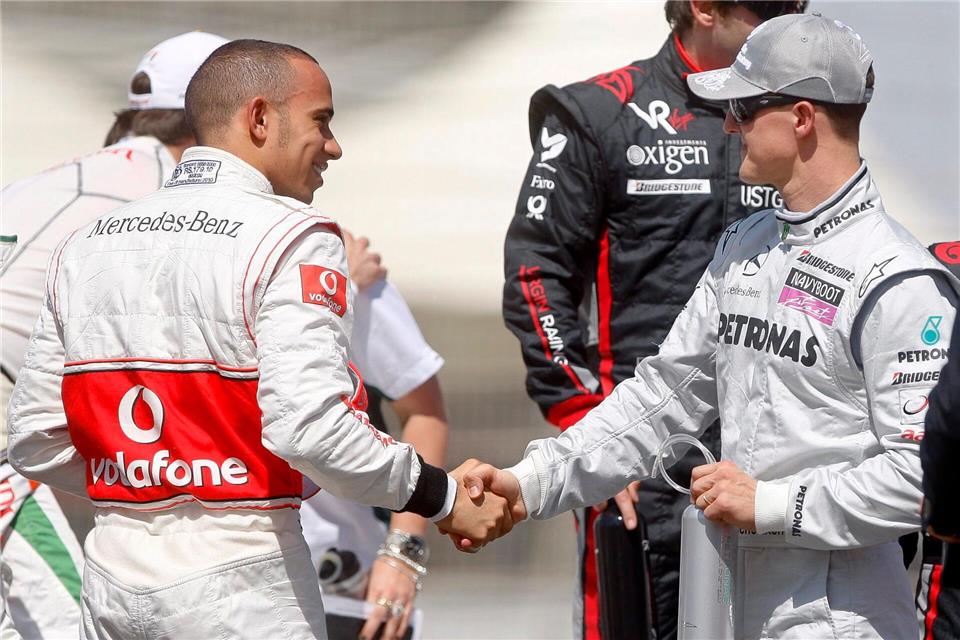 Lewis Hamilton (l) sieht das größte Vermächtnis von Michael Schumacher abseits der Rennstrecke. (Archivbild)Diego Azubel/dpa