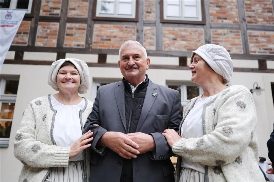 Liane Hellwig und Heike Liesaus vom Museumsdorf Dübener Heide e.V. herzen den Christoph Pillich, den Präsidenten der Deutschen Gesellschaft für Mühlenkunde und Mühlenerhaltung. Sebastian Willnow/dpa