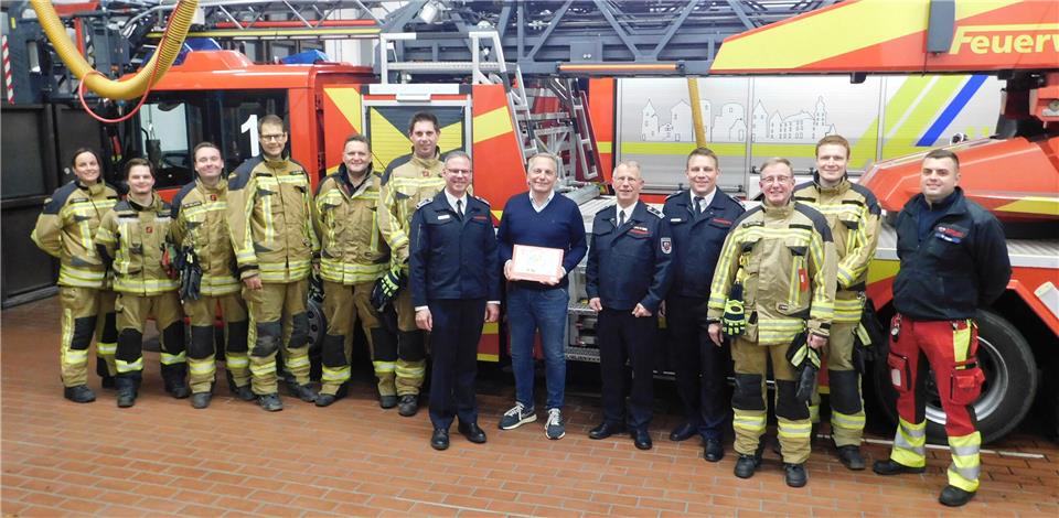 Löschzugführer Andreas Saure (5.v.r.), Stellvertreter Kai Sobbe (7.v.r.) und Matthias Hanne (4.v.r.) überreichen die Spende an Rainer Schwital, Geschäftsführer Förderverein Kinderkrebshilfe Münster, im Kreis der Feuerwehrfrauen und -männer