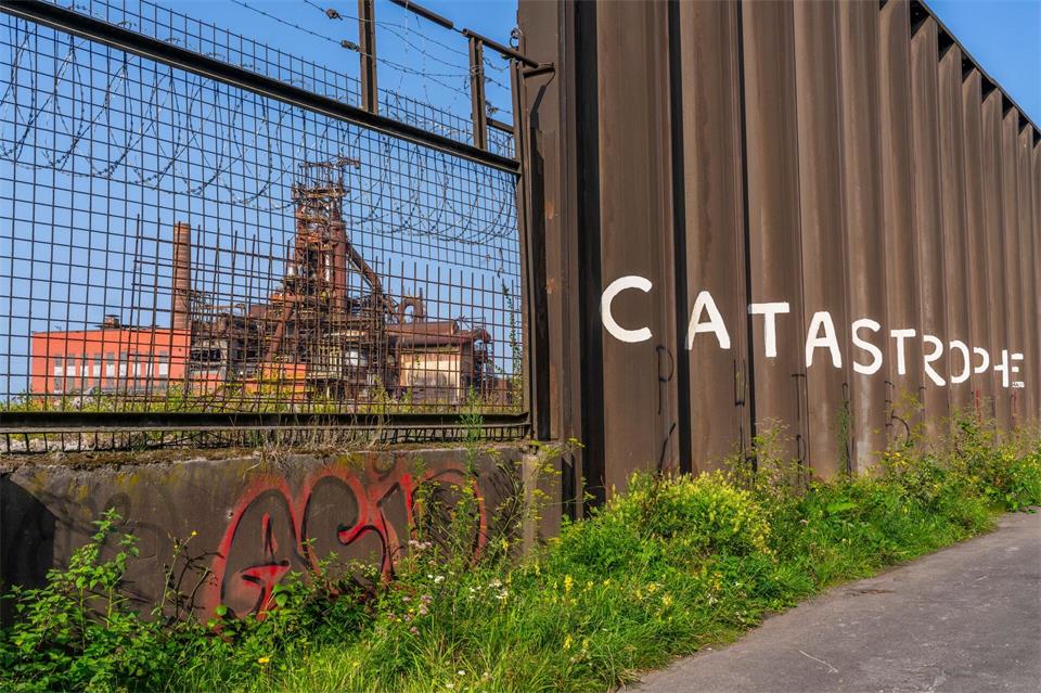 Lost Place mit einem einstigen Stahlwerk am Wanderweg „Boucle Noire“: „Catastrophe“ steht an einer Wand aus Stahl.Oliver Gerhard/dpa-tmn