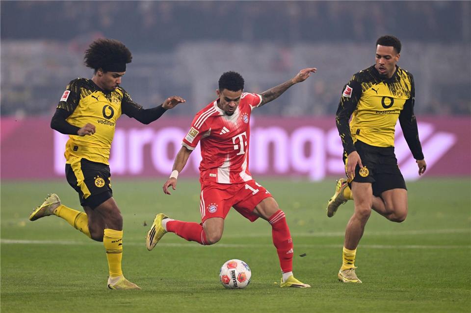 Luis Díaz umzingelt von zwei Dortmundern.David Inderlied/dpa