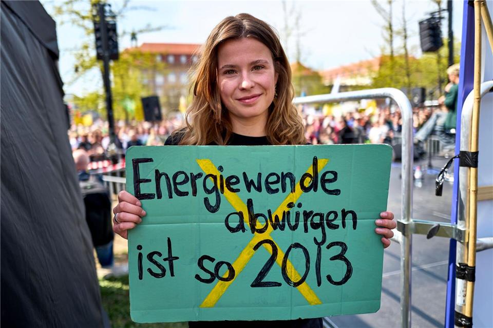 Luisa Neubauer hält ein Schild mit der Aufschrift „Energiewende abwürgen ist so 2013“ in der Hand. Michael Ukas/dpa