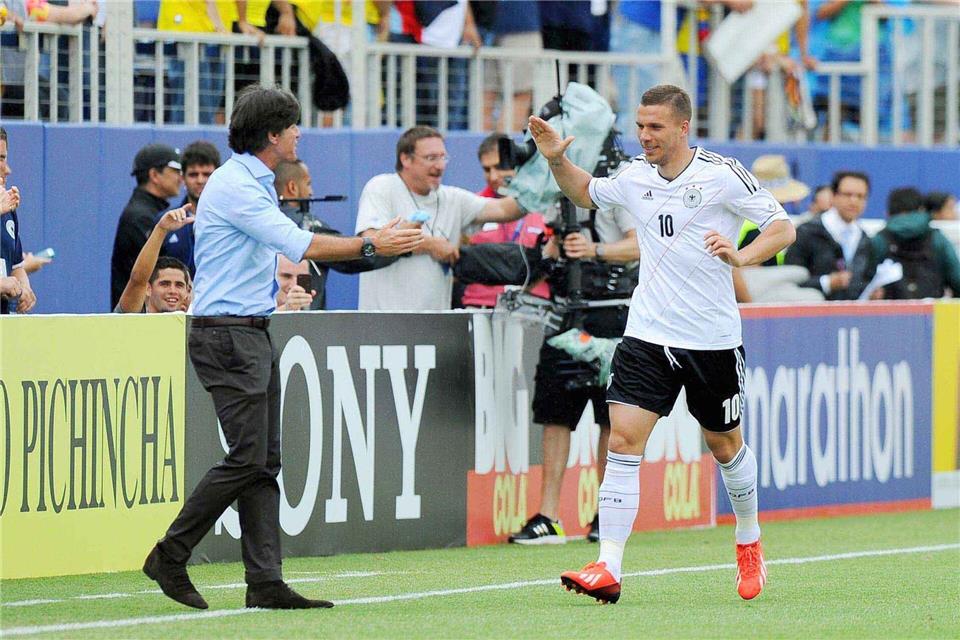 Lukas Podolski klatscht nach seinem Tor nach acht Sekunden mit Bundestrainer Joachim Löw ab. (Archivbild) picture alliance / dpa