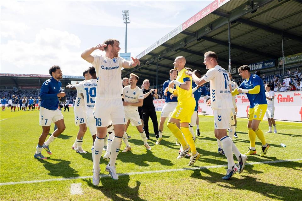 Magdeburger Spieler feiern nach dem Sieg in Kiel.Philipp Szyza/dpa