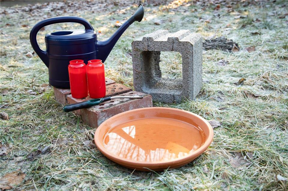 Man braucht: Ziegelsteine, einen Pflanzstein, einen Blumenuntersetzer und Grablichter.Christin Klose/dpa-tmn