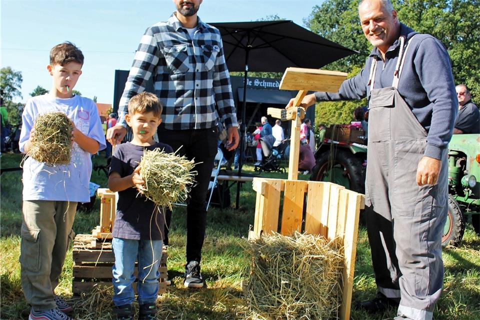 Manfred Schreiber (r.) hatte eine historische Strohpresse mit auf den Bauernmarkt gebracht.