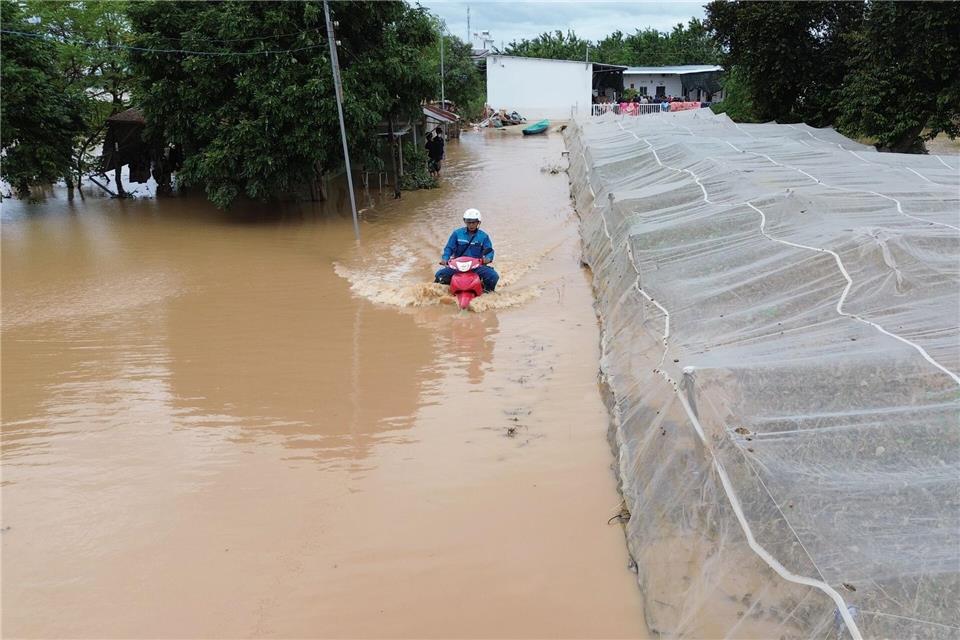 Mann kämpft sich auf überfluteter Straße durch die Fluten in Zentralvietnam--/VNA/XinHua/dpa