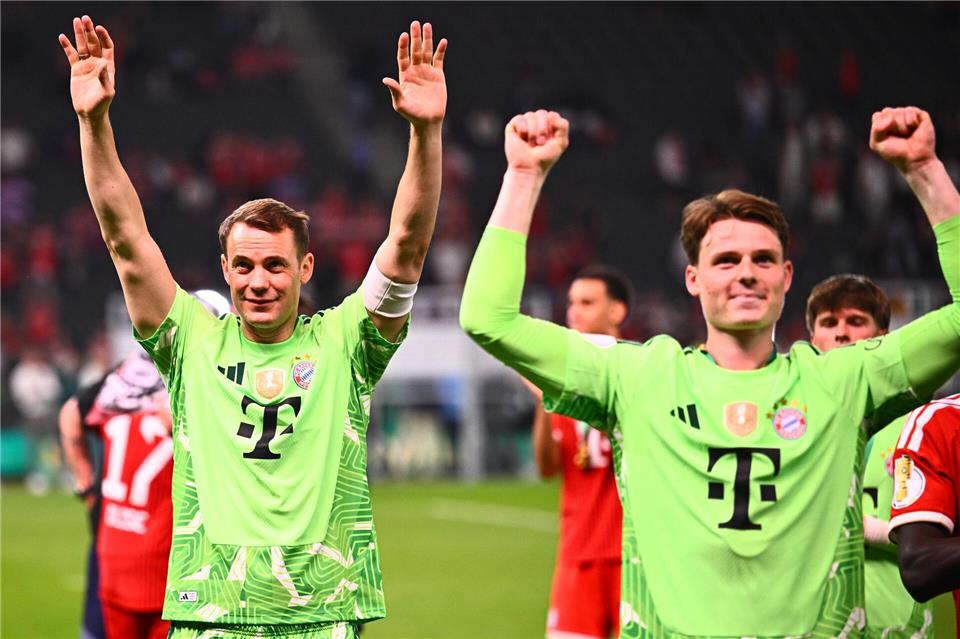 Manuel Neuer (l.) und Jonas Urbig (r.) feiern den Pokalsieg. Tom Weller/dpa