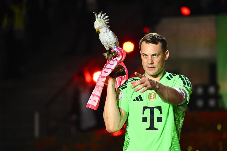 Manuel Neuer trägt nach dem Pokalsieg die Kakadu-Trophäe des FC Bayern. Tom Weller/dpa
