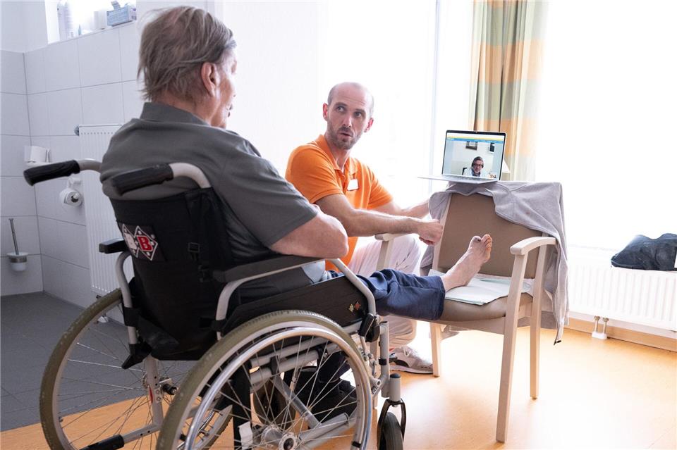 Marc Ulbricht, Wohnbereichsleiter, neben Bewohner Lutz Kiesewalter im Pflegeheim „Herbstsonne“ während einer Videosprechstunde mit Antonio Kantchew-Haustein.Sebastian Kahnert/dpa