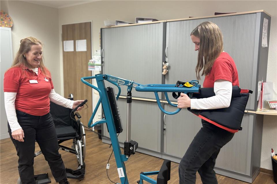 Maren Deppe (r.) und Katharina Langer-Koulik demonstrieren einen Patientenlift. Dieser soll den Arbeitsalltag von Pflegekräften vereinfachen.