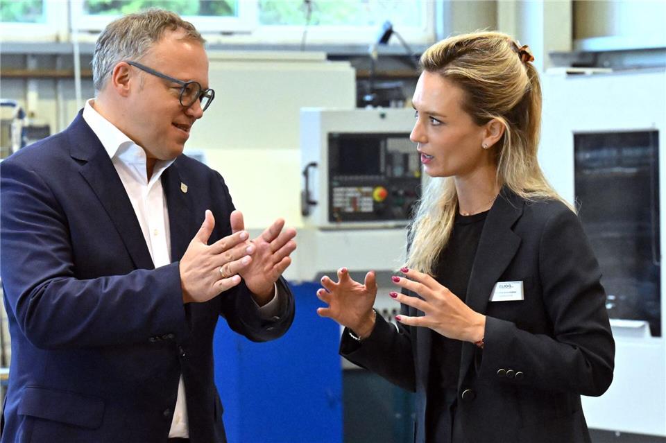 Mario Voigt (l, CDU), Ministerpräsident von Thüringen, spricht mit Karlotta Gründobler, Geschäftsführerin der Eliog Industrieofenbau GmbH. Voigt sieht überbordende Bürokratie als zunehmende Belastung für Thüringer Unternehmen. Martin Schutt/dpa